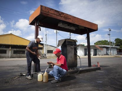 Dois homens enchem galões com gasolina em Chivacoa (Venezuela), em 13 de outubro de 2019.
