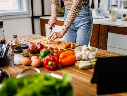 Una mujer prepara una comida con vegetales.