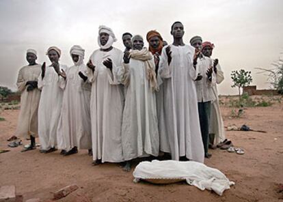 Los familiares de Alí, un niño de un año que murió el pasado 21 de junio de malnutrición en un campo de refugiados de Darfur, rezan sobre su cadáver.