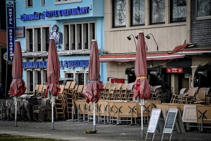 Mesas y sillas almacenadas frente a restaurantes cerrados en Colonia, Alemania.