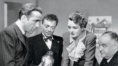 Humphrey Bogart sostiene la estatuilla del halcón maltés, ante las miradas (desde la izquierda) de Peter Lorre, Mary Astor y Sydney Greenstreet, en la película 'El halcón maltés', de John Huston.