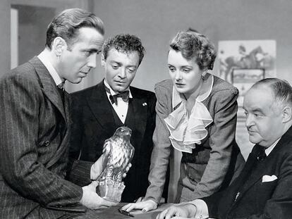 Humphrey Bogart sostiene la estatuilla del halcón maltés, ante las miradas (desde la izquierda) de Peter Lorre, Mary Astor y Sydney Greenstreet, en la película 'El halcón maltés', de John Huston.