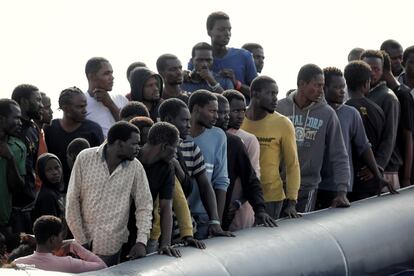 Migrantes a bordo de la patera observan la aproximación del equipo de rescate.