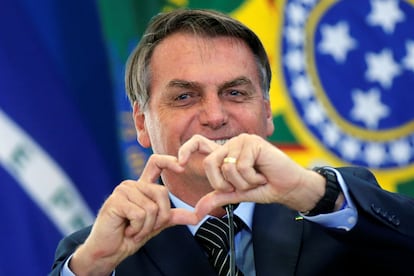 O presidente Jair Bolsonaro faz sinal de coração em evento sobre programa da Caixa Econômica Federal em Brasília.