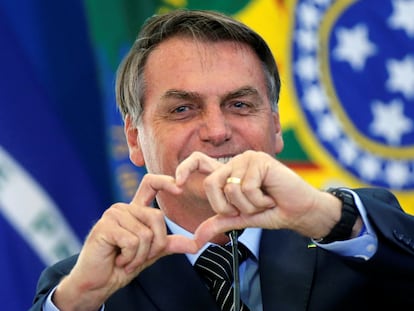 O presidente Jair Bolsonaro faz sinal de coração em evento sobre programa da Caixa Econômica Federal em Brasília.