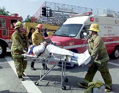 Uno de los heridos el jueves en la entrada del Shrine Auditorium de Los Ángeles es llevado a una ambulancia.