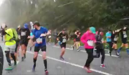 Corredores tapándose de la granizada en la carrera popular de la Behobia en una imagen difundida por la organización.