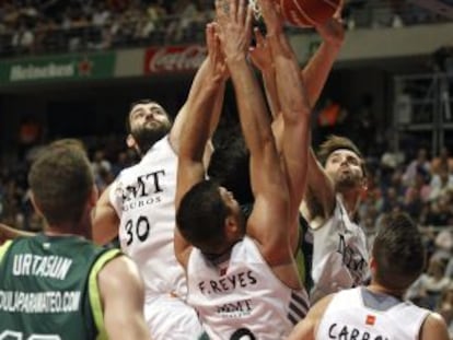 Los jugadores de Madrid y Unicaja luchan en la zona.