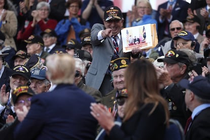 Donald y Melania Trump observan el cartel de un veterano de la Segunda Guerra Mundial, durante el homenaje en el cementerio norte estadounidense de Colleville-sur-Mer, Normandía.