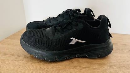 Zapatillas para caminar sobre una pared gris.