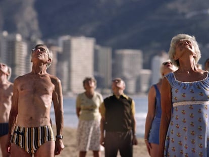 Un grupo de mayores hace gimnasia en una playa de Benidorm.