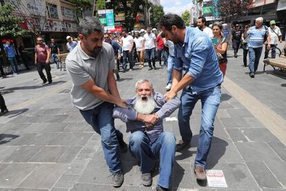 Dos policías detienen a un manifestante durante una protesta contra la detención de dos profesores que permanecían en huelga de hambre, en Ankara (Turquía).