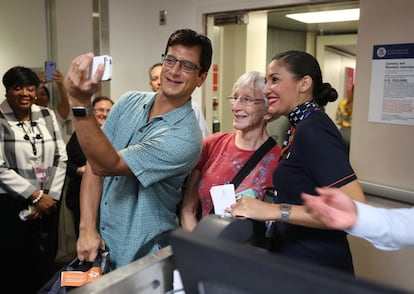 Pasajeros se sacan una selfi con una de las azafatas del primer vuelo comercial entre Estados Unidos y Cuba, en el Aeropuerto Internacional de Fort Lauderdale en Florida (EE.UU).
