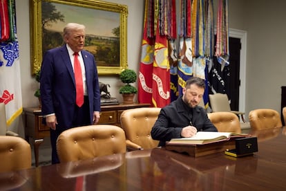 Zelenski firma en el libro de visitas tras reunirse con Trump.