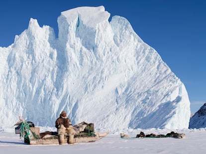 Un hombre inuit, con su canoa y sus perros.