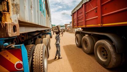 Un niño se busca la vida vendiendo agua mineral a los camioneros que esperan en la cola.