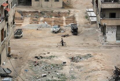 Un hombre camina junto a su bicicleta por una calle en la ciudad siria de Hazzeh, el 28 de marzo de 2018.