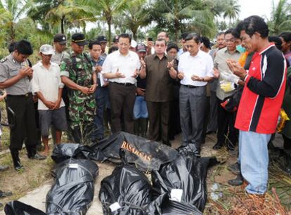 El vicepresidente indonesio (cuarto por la derecha) reza ante víctimas del <i>tsunami</i> en Muntai Baru.