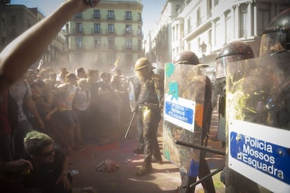 Enfrentamiento entre 'mossos' cubiertos de pintura y de polvos holi y manifestantes independentistas.