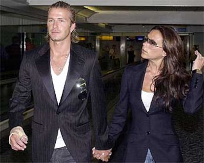 El jugador inglés y su mujer, Victoria Beckham, esperan hoy en  el aeropuerto de Heatrow el vuelo a Tokio.