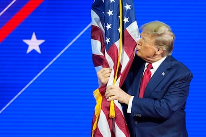 Republican presidential candidate former President Donald Trump hugs and kisses the American flag as he speaks at the Conservative Political Action Conference, CPAC 2024, at National Harbor, in Oxon Hill, Md., Saturday, Feb. 24, 2024.