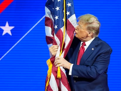 Republican presidential candidate former President Donald Trump hugs and kisses the American flag as he speaks at the Conservative Political Action Conference, CPAC 2024, at National Harbor, in Oxon Hill, Md., Saturday, Feb. 24, 2024.