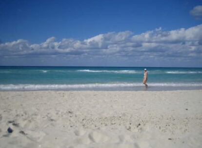 Una turista pasea por la orilla de una playa en Varadero