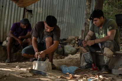 Trabajadores de la mina Santa Elena muelen la piedra para obtener una muestra de metales. 