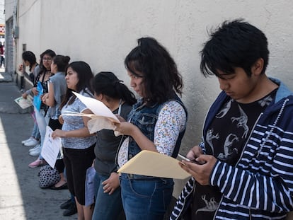 Jóvenes hacen fila para realizar el examen de ingreso a la UNAM, a las afueras de un centro educativo en Ciudad de México.