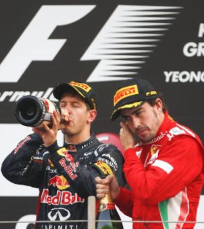 Sebastian Vettel (l) drinks champagne on the podium after winning the South Korean Grand Prix next to third-placed Fernando Alonso.