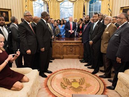 La consejera del presidente Kellyanne Conway revisa su teléfono tras tomar una foto a Donald Trump y un grupo de líderes de universidades afroamericanas.
