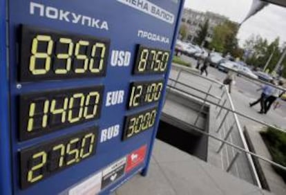 Vista de un cartel con el tipo de cambio aplicable entre el rublo bielorruso y el dólar (arriba), euro (centro) y rublo ruso (abajo) en una oficina de cambio de Minsk, Bielorrusia. EFE/Archivo