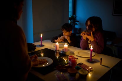 Una familia cena a la luz de las velas en Barcelona, el lunes.
