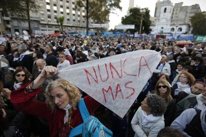 Marchers hold a sign reading Never Again.