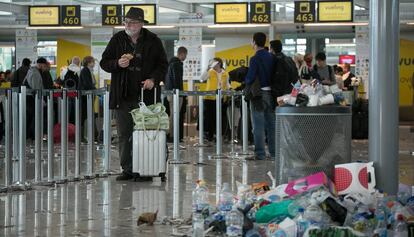 Un turista s'espera a la T1 de l'aeroport del Prat entre escombraries.