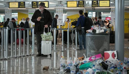 Un turista s'espera a la T1 de l'aeroport del Prat entre escombraries.