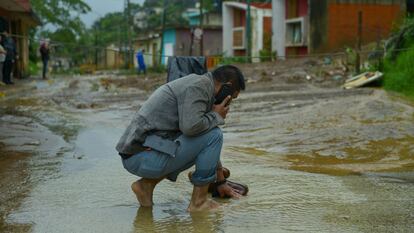 Un hombre limpia sus zapatos en la corriente provocada por las inundaciones en Xalapa, Veracruz, el 1 de julio 2024.