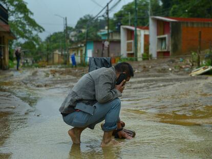 Un hombre limpia sus zapatos en la corriente provocada por las inundaciones en Xalapa, Veracruz, el 1 de julio 2024.
