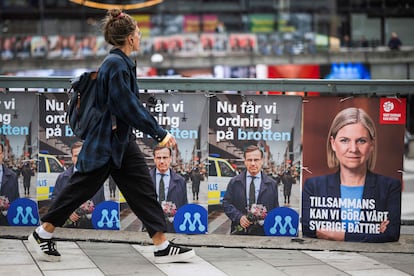 Una mujer camina junto a carteles electorales de Ulf Kristersson, líder del Partido de los Moderados, y de Magdalena Andersson, primera ministra y líder de los socialdemócratas, este jueves en Estocolmo.