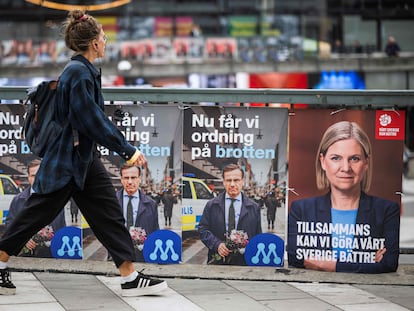 Una mujer camina junto a carteles electorales de Ulf Kristersson, líder del Partido de los Moderados, y de Magdalena Andersson, primera ministra y líder de los socialdemócratas, este jueves en Estocolmo.