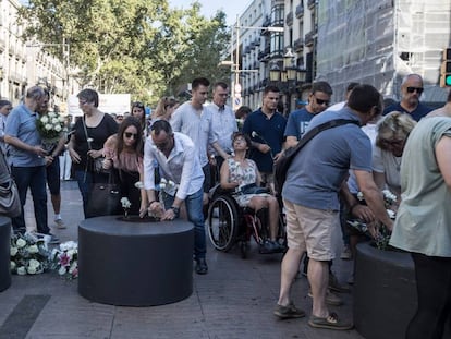 Víctimes i familiars realitzen una ofrena floral a la Rambla.