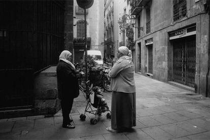 Dos inmigrantes conversan en la plaza de En Marcús, en el Casc Antic de Barcelona.