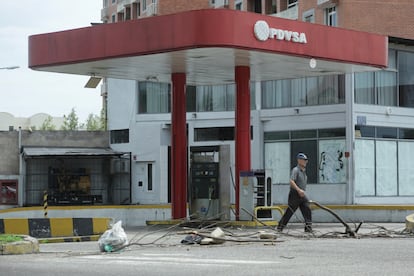 Un hombre camina frente a una gasolinera de PDVSA, en San Cristóbal (Venezuela).