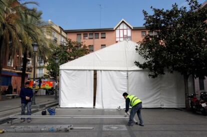 Varios operarios montan una carpa fallera en una plaza de Valencia.