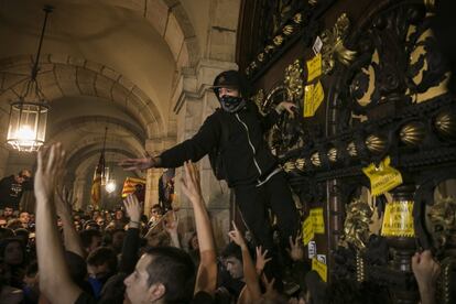 Grups de manifestants arriben a les portes del Parlament després de trencar el cordó policial i col·loquen adhesius amb el lema “República en construcció”, després de la marxa a Barcelona pel primer aniversari del referèndum il·legal de l'1 d'octubre.