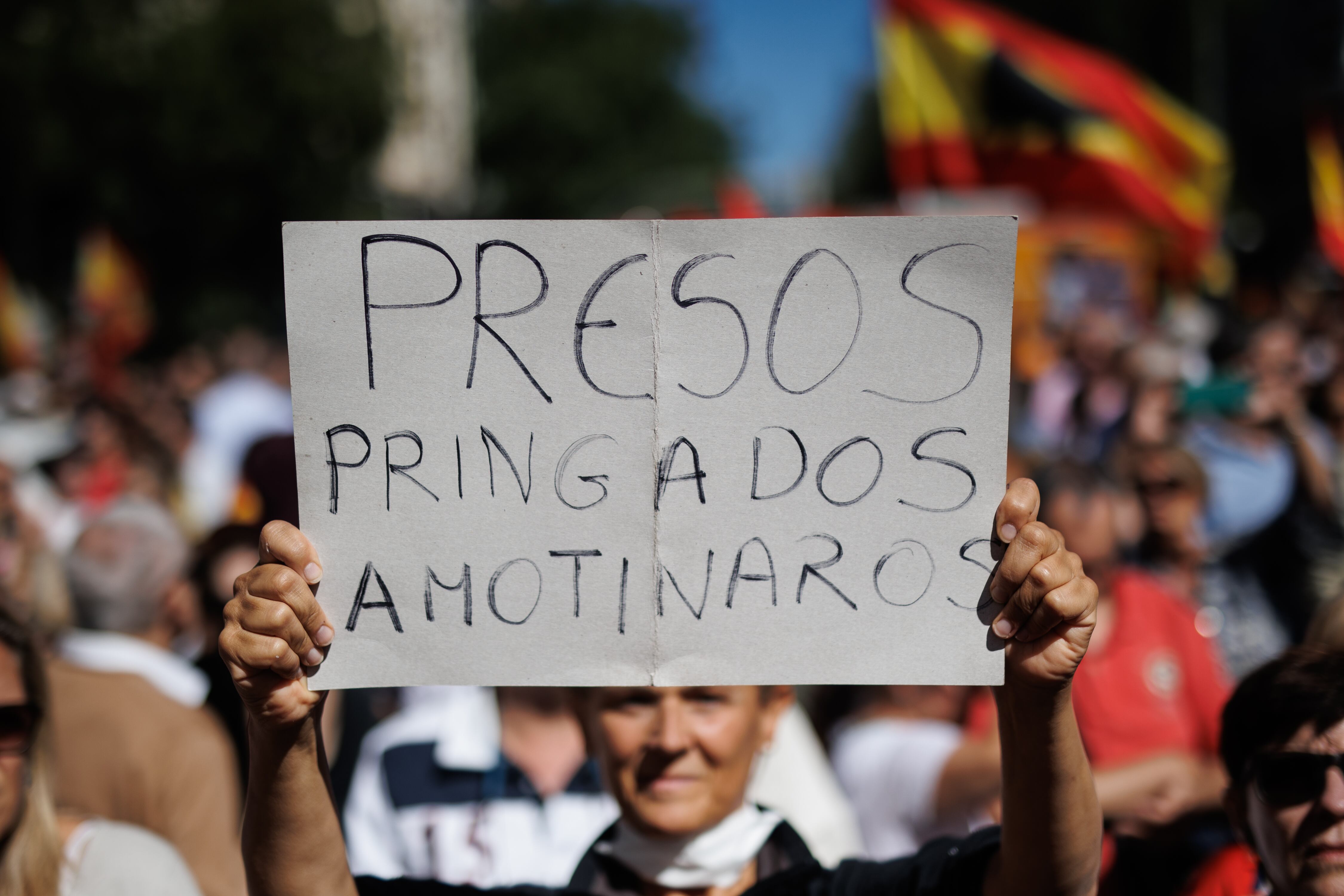 Una persona sujeta una pancarta durante la manifestación organizada por el PP, este domingo en Madrid. 
