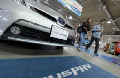 Visitantes caminan junto a un vehículo híbrido de Toyota, durante una feria en Tokio, Japón. EFE/Archivo