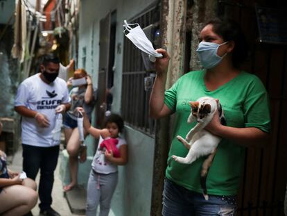 Residentes de la favela Heliopolis, en Sao Paulo, muestran las mascarillas recibidas para protegerse de la covid-19.