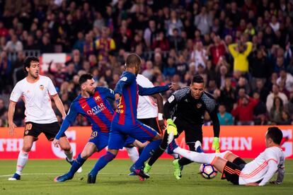 Lionel Messi y Rafinha del Barcelona intentan anotar bajo la presión de Dani Parejo, el portero Diego Alves y Fabián Orellana del Valencia.