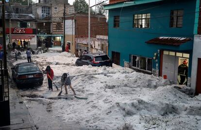 Soldados y vecinos retiran granizo de las calles en Puebla, el 24 de mayo.